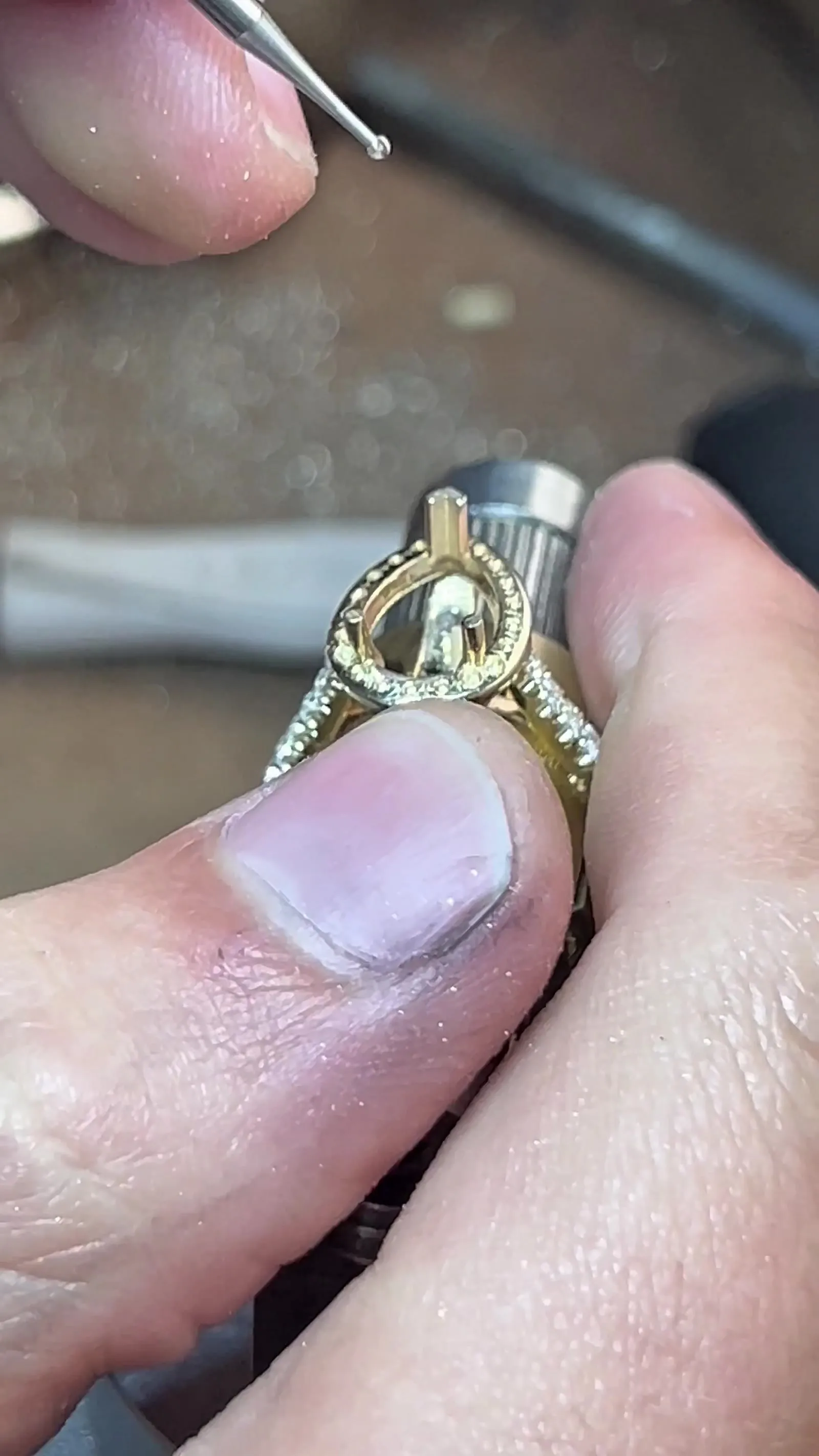 Close-up of a stone being set with a hand tool